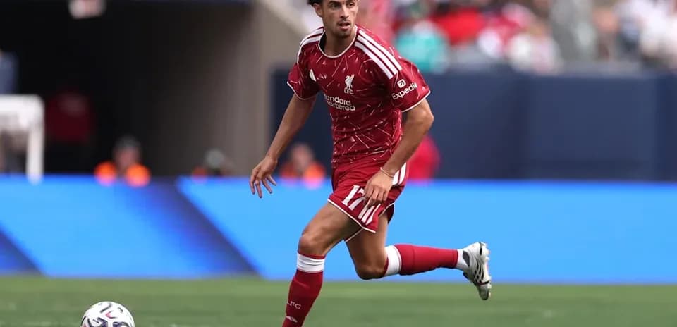 Player in red kit dribbling ball on field