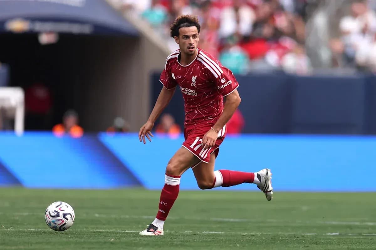 Player in red kit dribbling ball on field