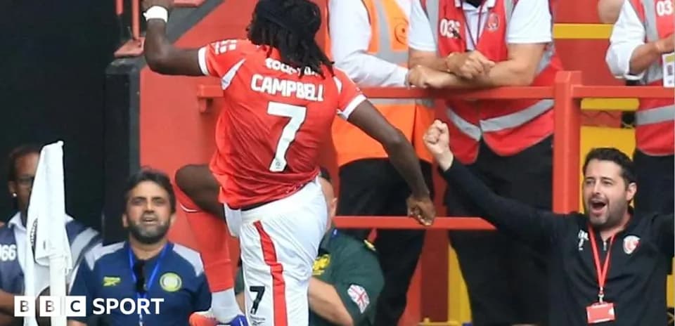 Player celebrating a goal with fans in stadium