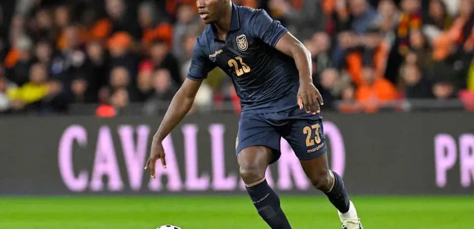 Player wearing blue kit dribbling ball during match