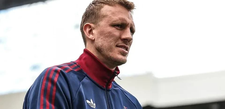 Player in team tracksuit at stadium entrance