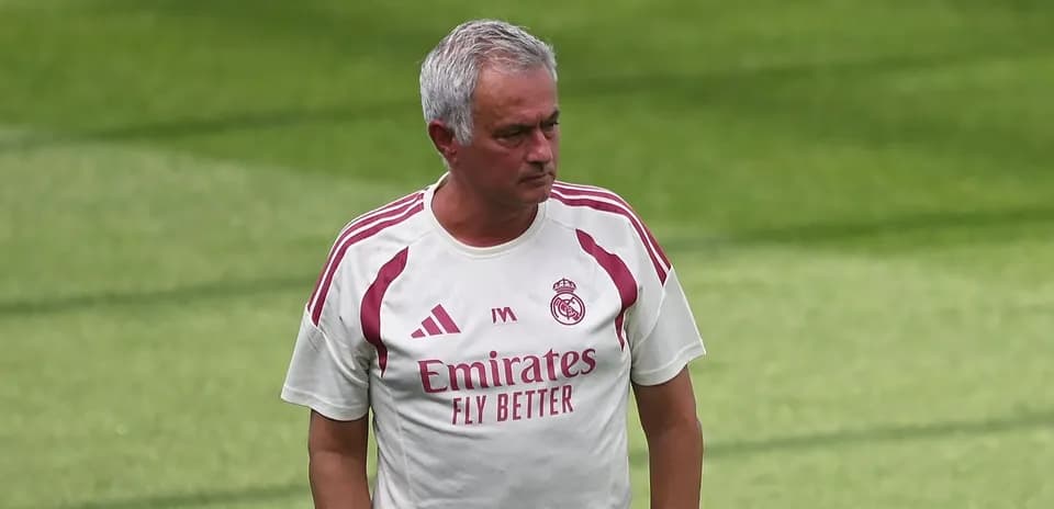 Manager walking on training pitch in club attire