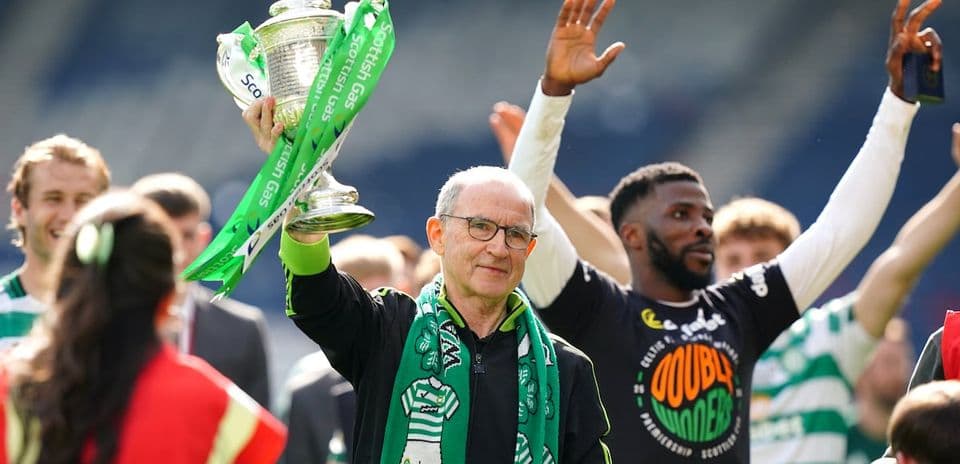 Man holding trophy with green ribbons in celebration