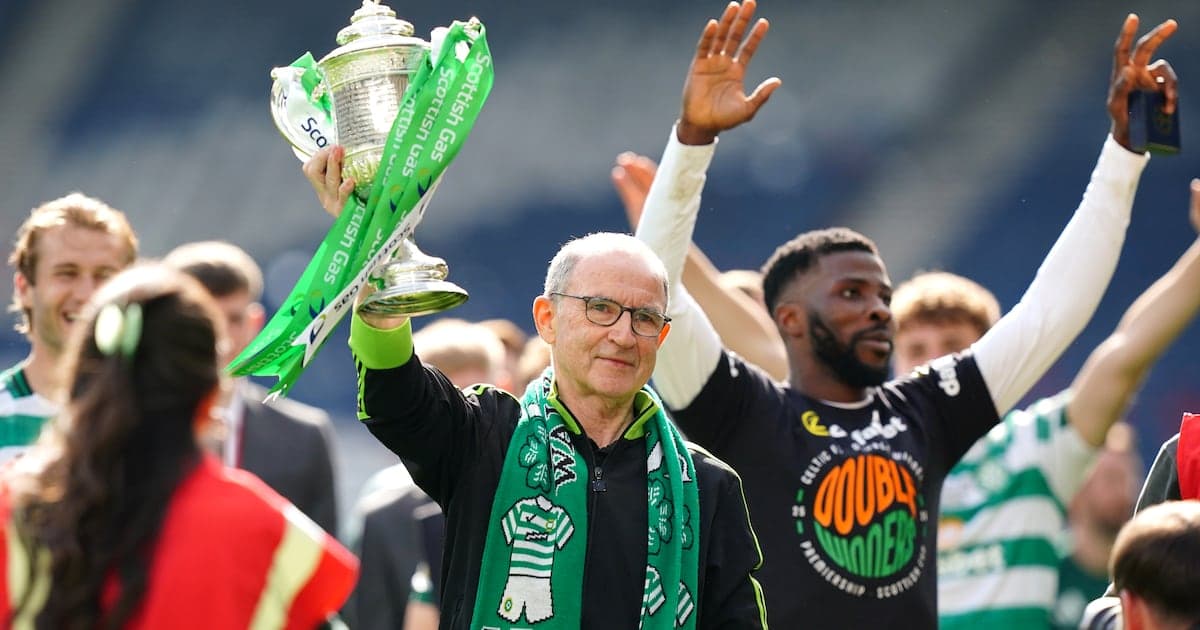 Man holding trophy with green ribbons in celebration