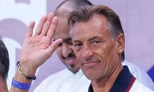 Coach waving during a press conference appearance