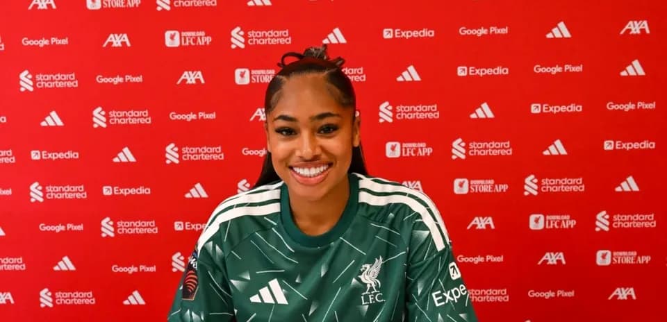 Player in Liverpool kit at press conference backdrop