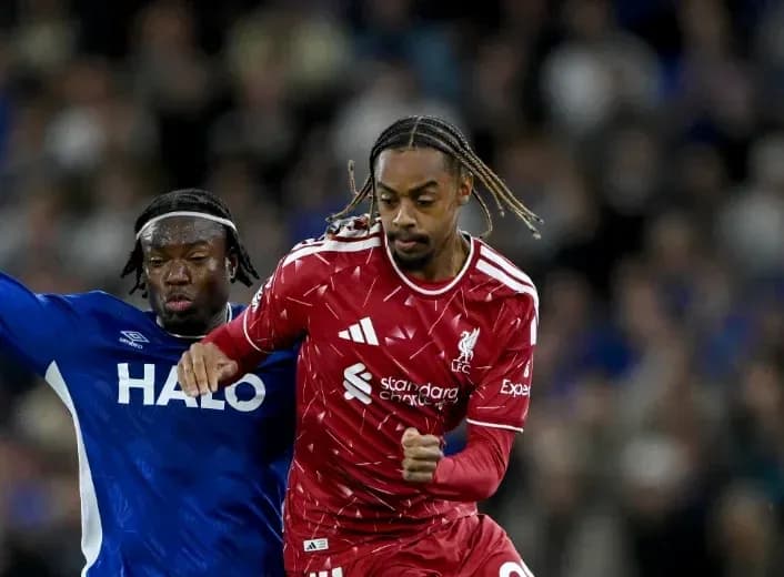 Player in red dribbling past opponent in blue