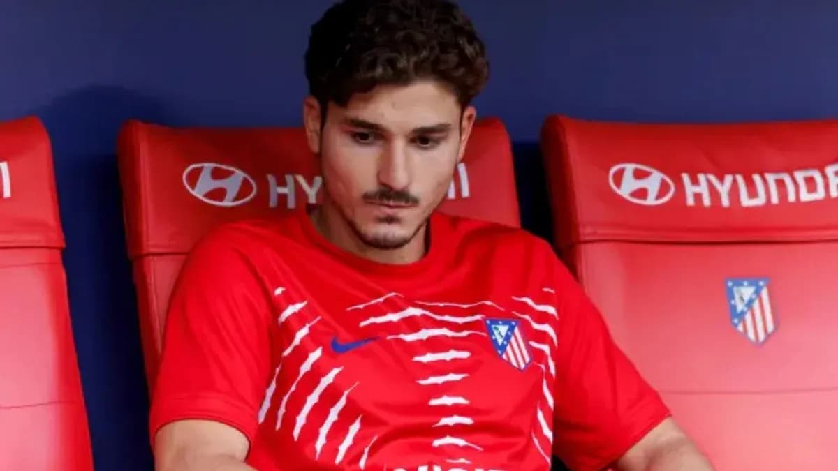 Player sitting on bench wearing Atlético Madrid kit