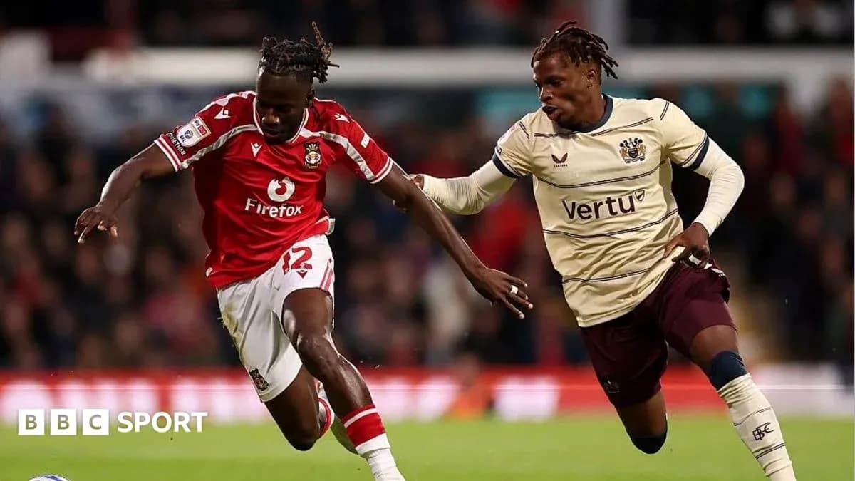 Player in red dribbling past opponent in beige jersey