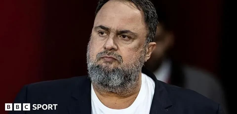Man with beard in black blazer, serious expression