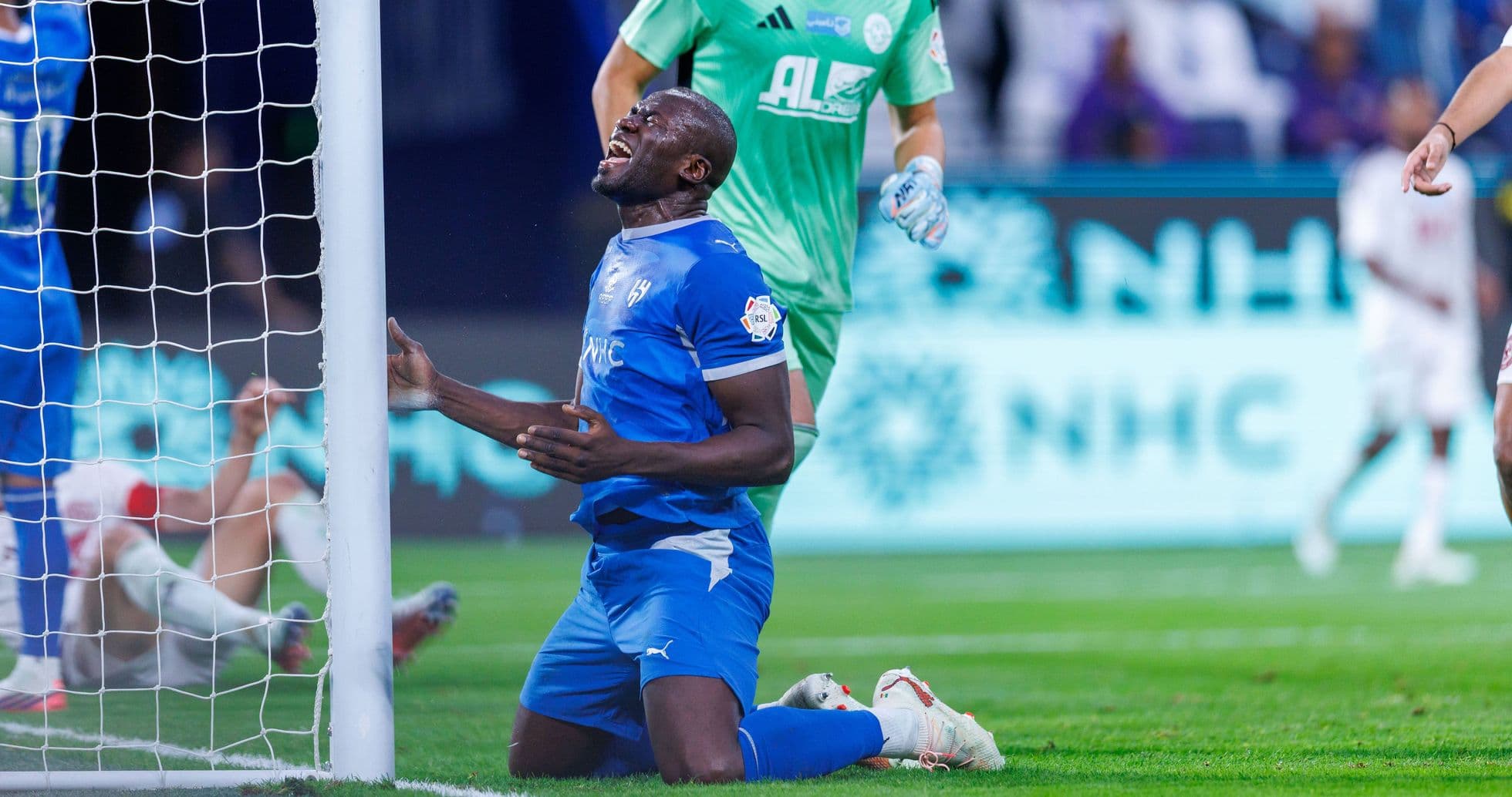 Player kneeling in front of goal after missed chance