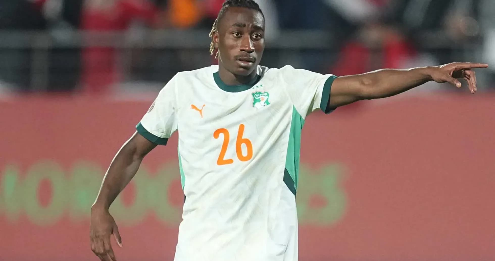 Player in Ivory Coast jersey directing teammates on field