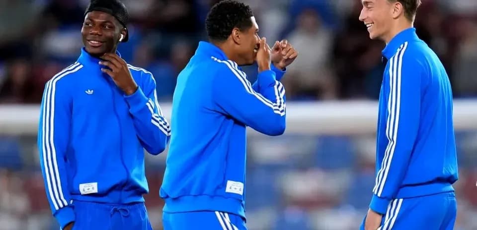 Three players in blue training outfits laughing together