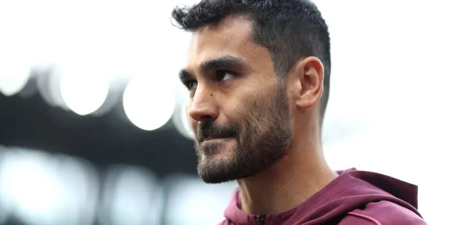 Player in maroon hoodie during match preparation