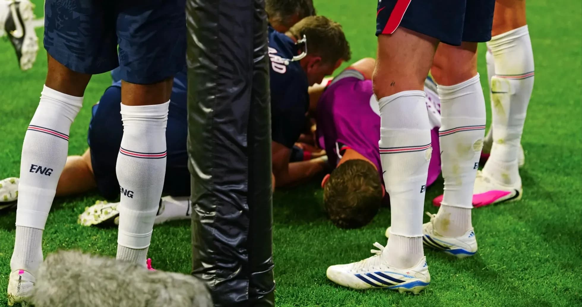 Players surrounding injured teammate on the field