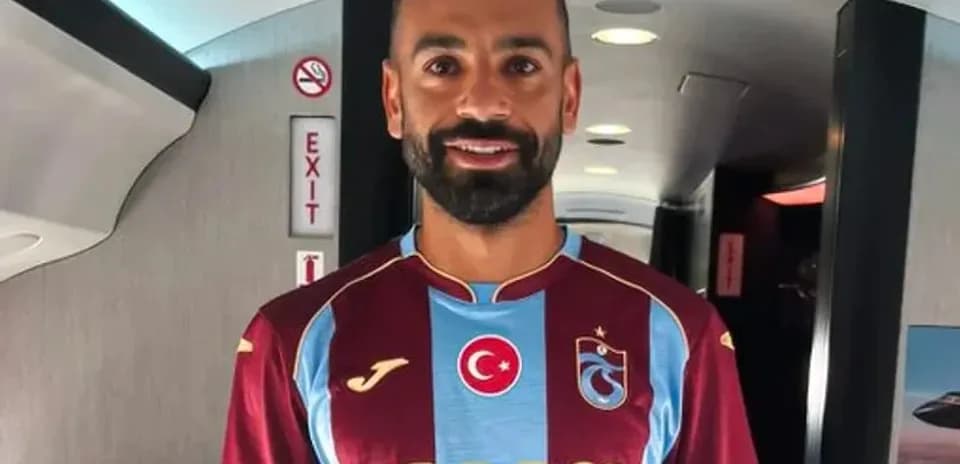 Player wearing Trabzonspor jersey in airplane corridor