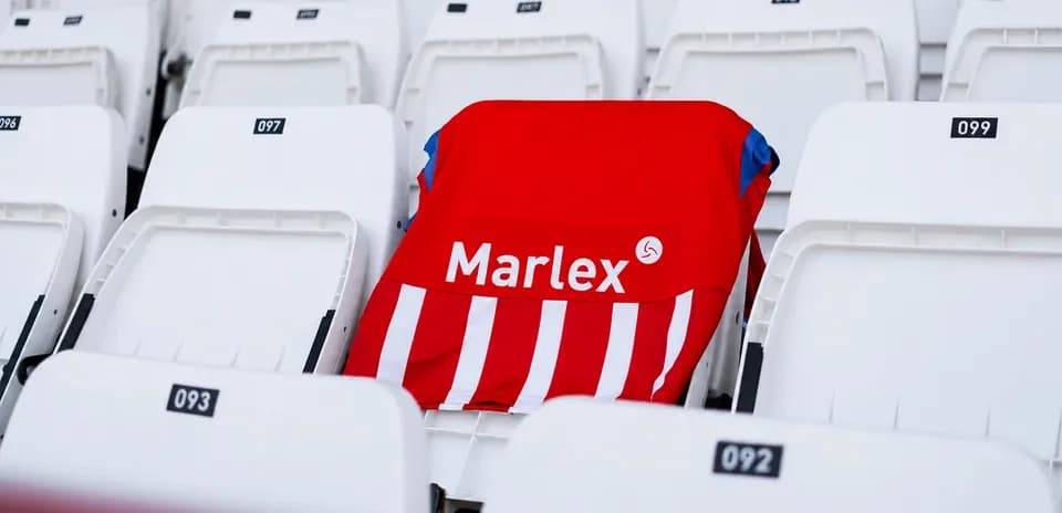 Red and white jersey placed on empty stadium seat