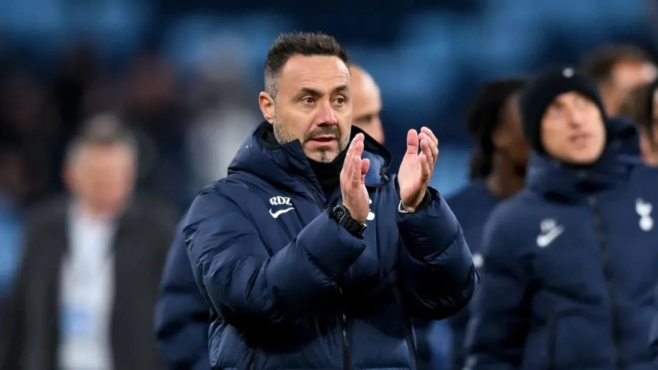 Manager applauding after match with team behind