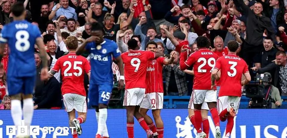 Players celebrating goal with fans in background