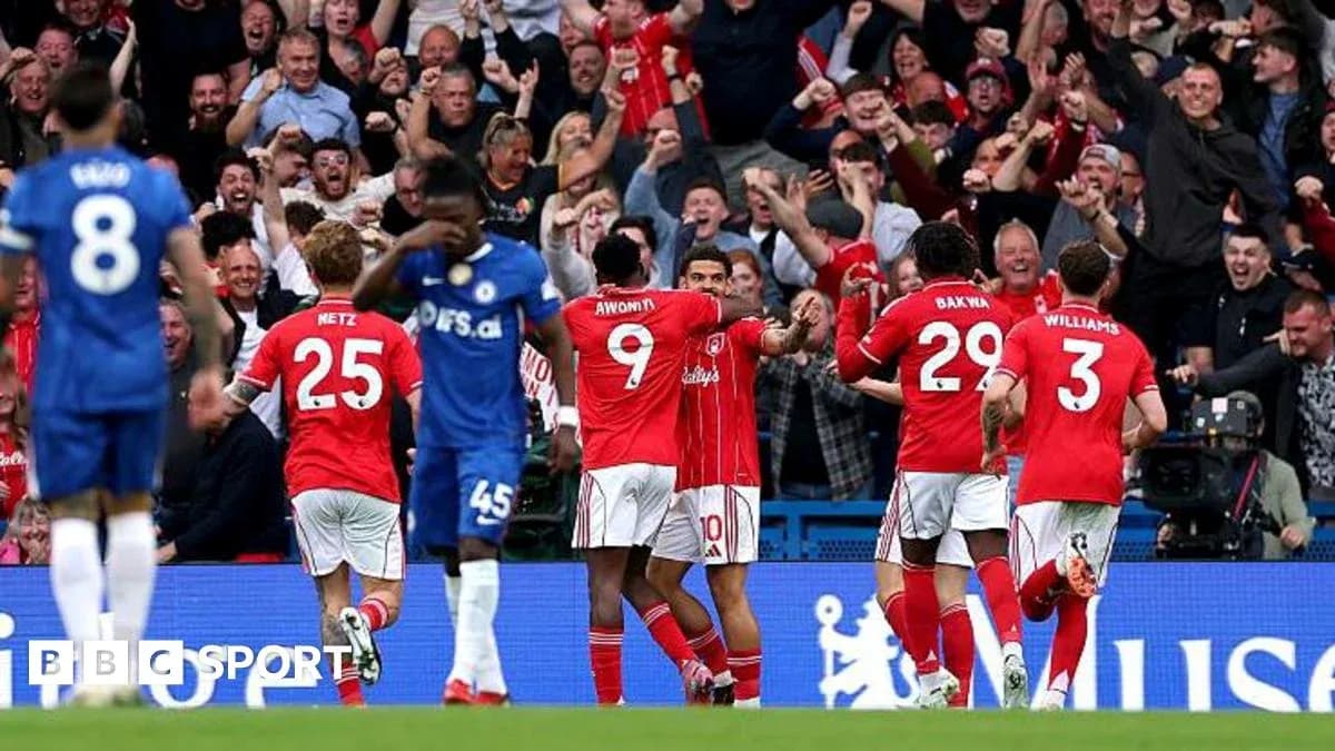 Players celebrating goal with fans in background