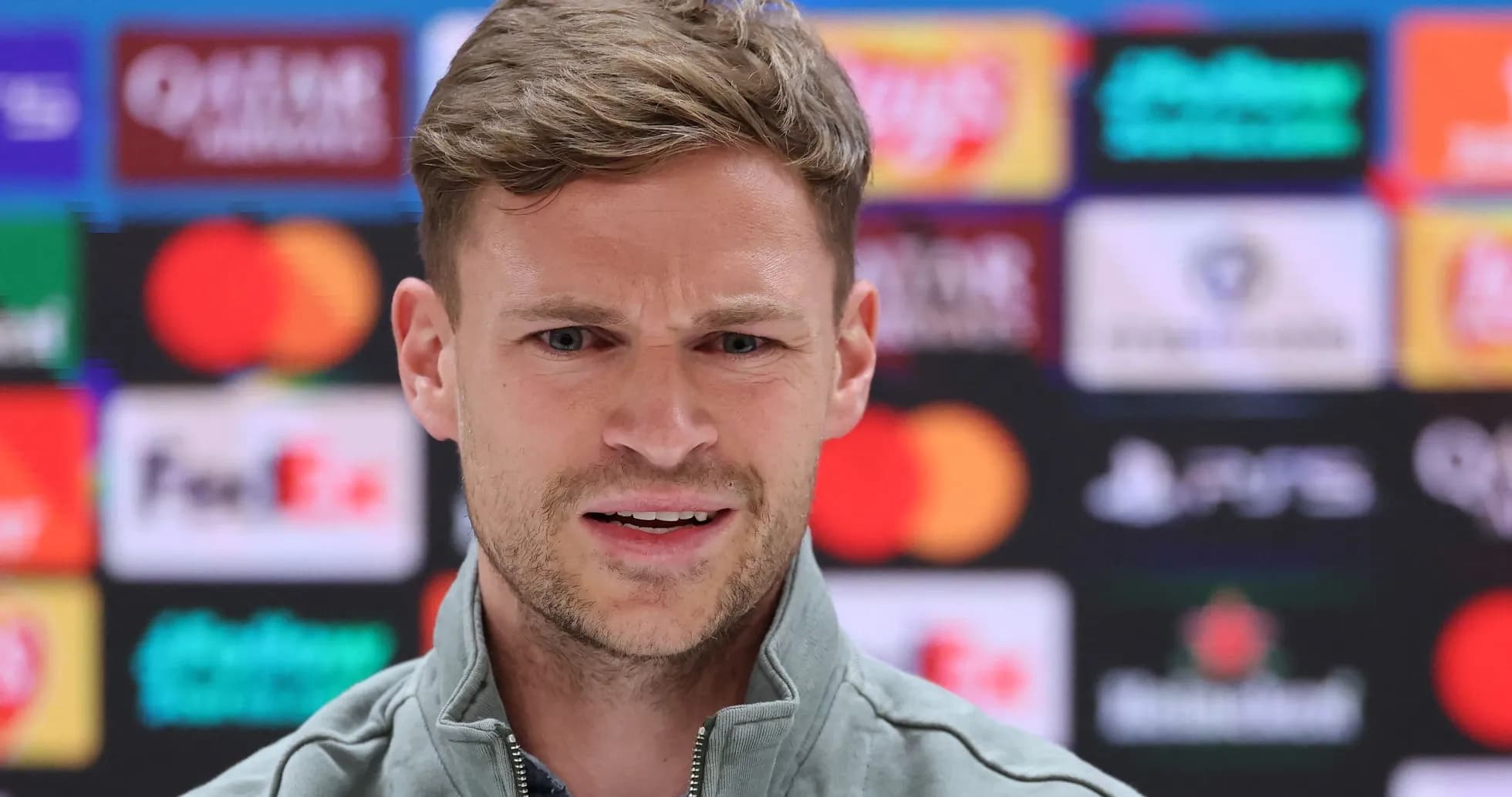 Manager speaking at press conference with sponsors backdrop