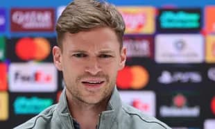 Manager speaking at press conference with sponsors backdrop