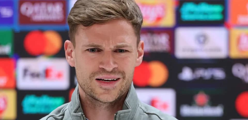 Manager speaking at press conference with sponsors backdrop