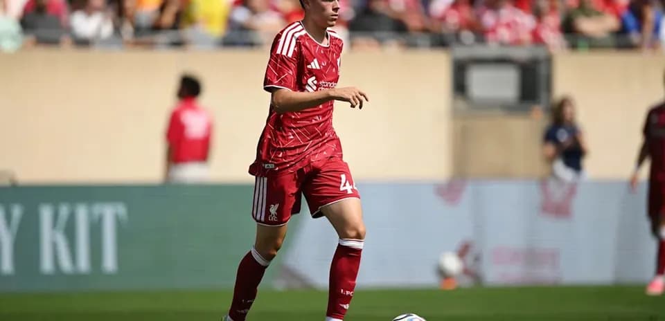 Liverpool player dribbling the ball on field
