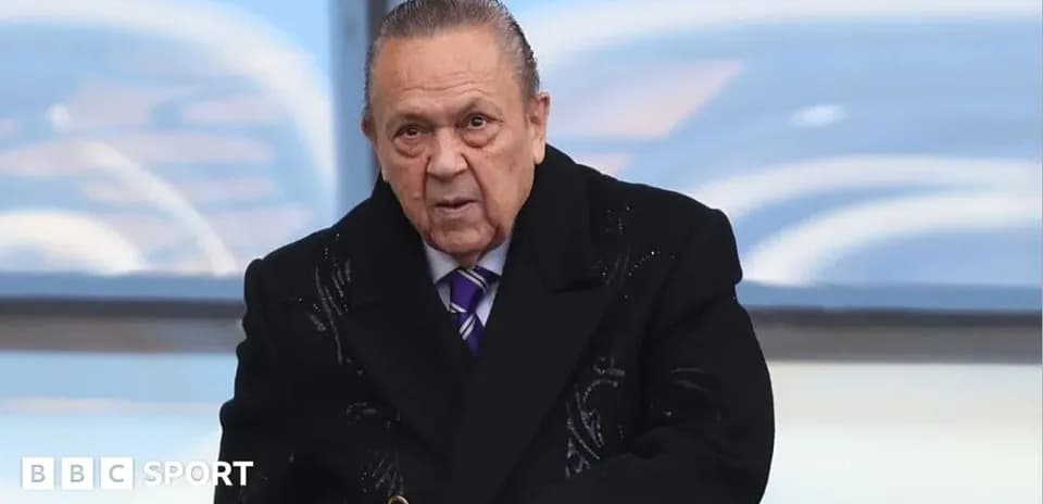 Man in a coat at a sports event