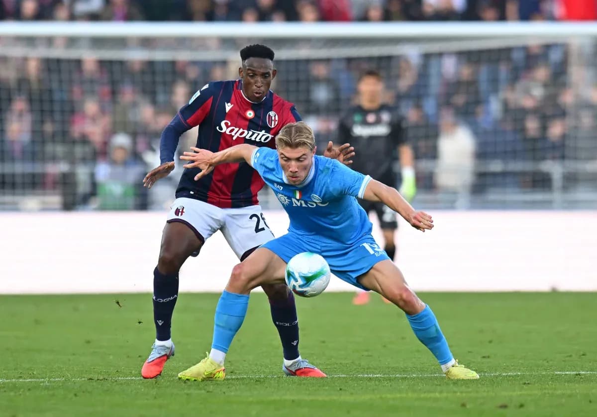 Napoli player challenging Bologna defender for the ball