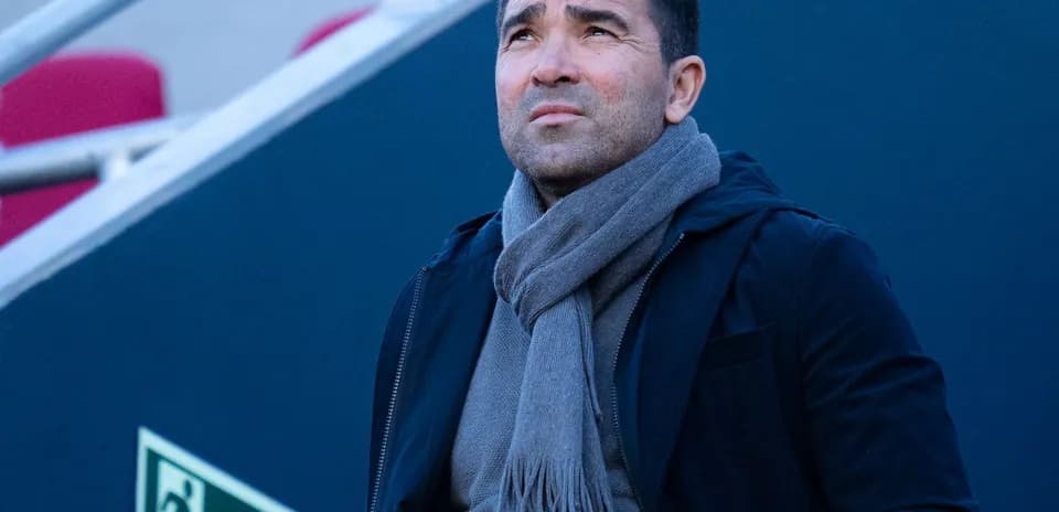 Man in coat and scarf looking upwards