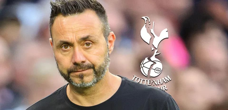 Manager standing with Tottenham Hotspur logo in background