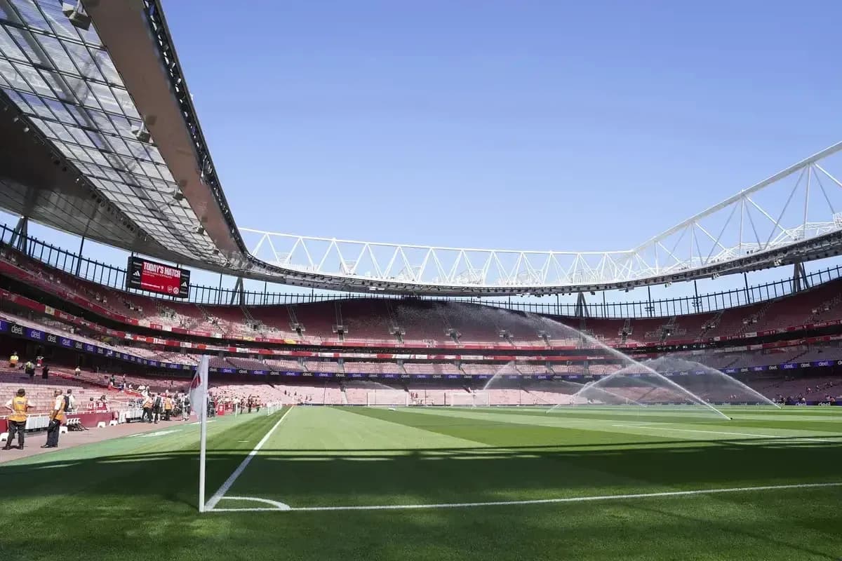 Empty stadium with sprinklers on the pitch