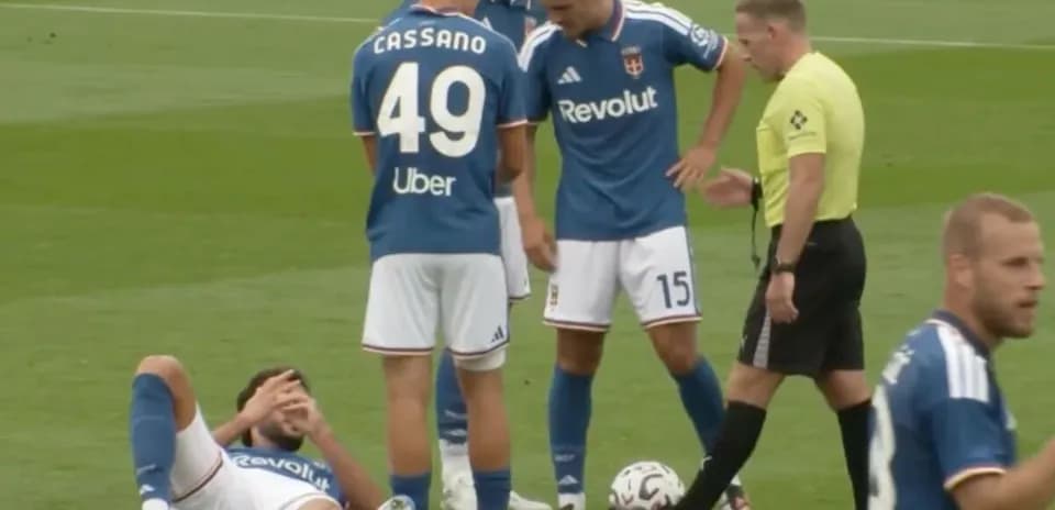 Player on ground with teammates and referee nearby