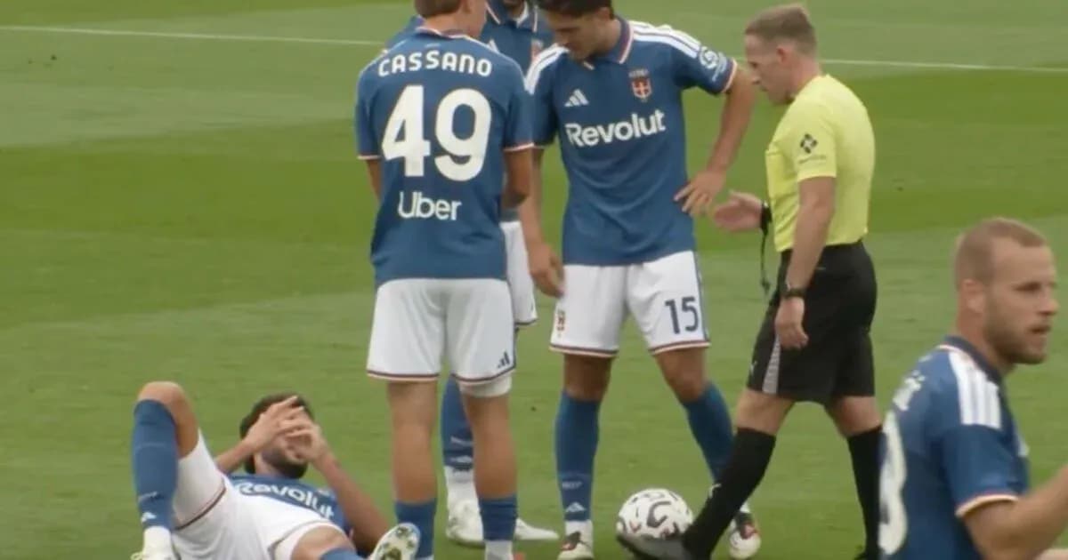 Player on ground with teammates and referee nearby