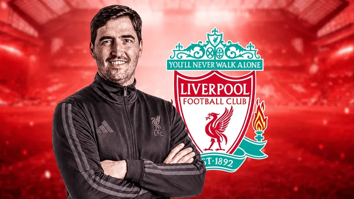 Coach standing in front of Liverpool FC logo