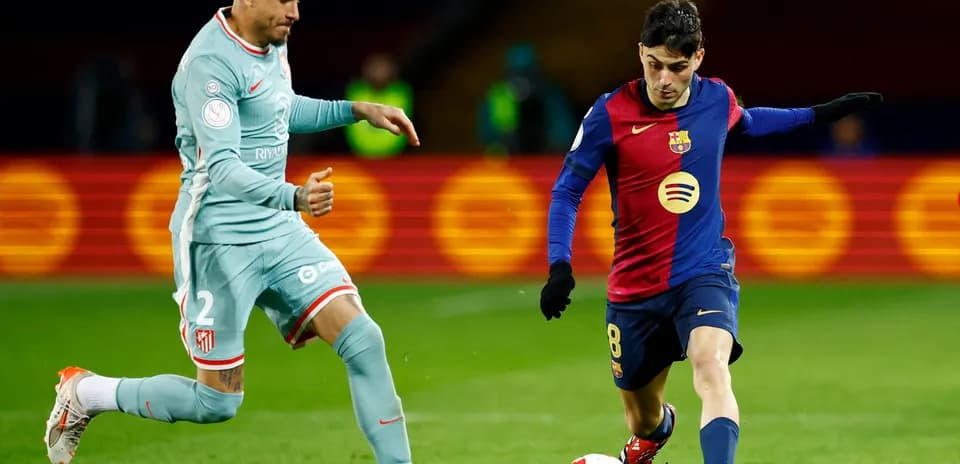 Atletico Madrid player defending against Barcelona