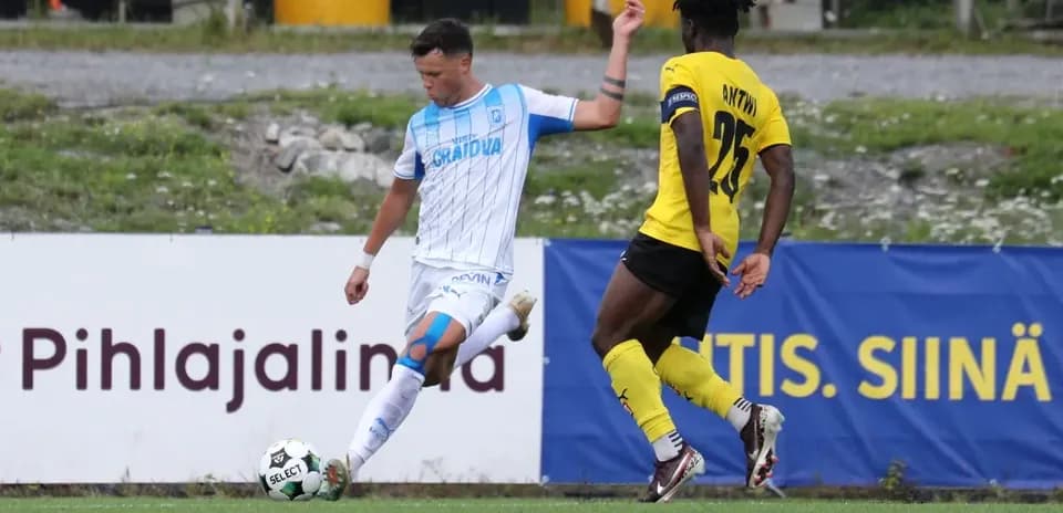 Universitatea Craiova player dribbling past KuPS defender