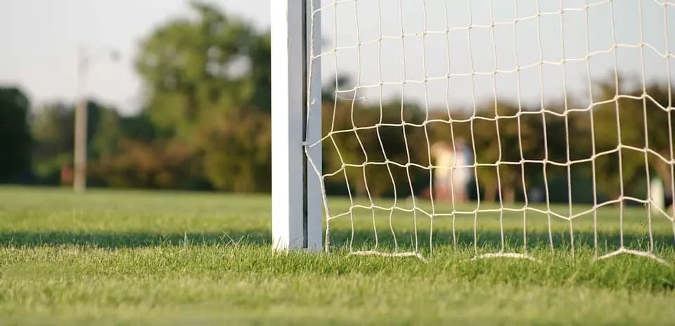 Close-up of soccer goal and net on field