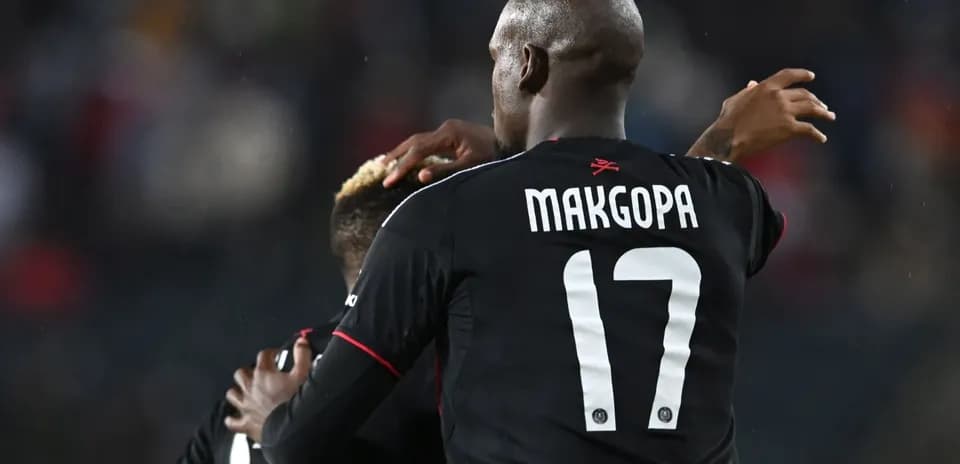 Player celebrating with teammate after scoring goal