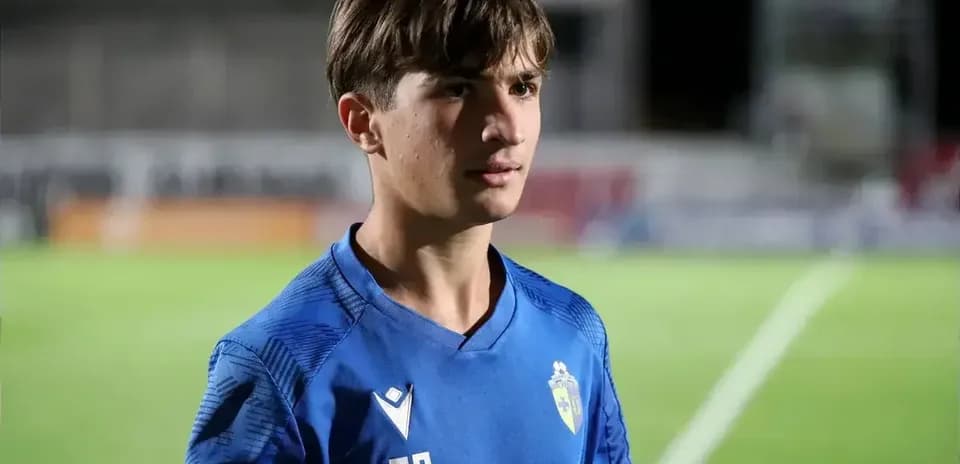 Young player in blue jersey standing on field