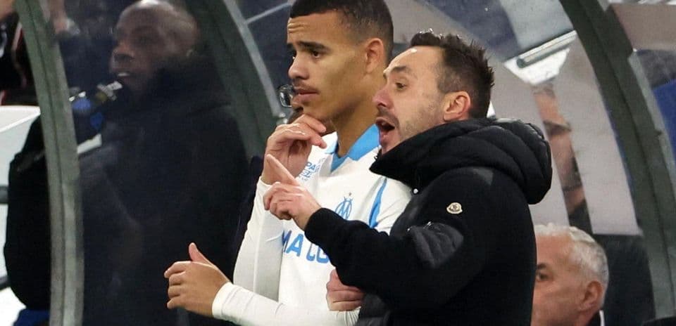 Coach giving instructions to player on sidelines
