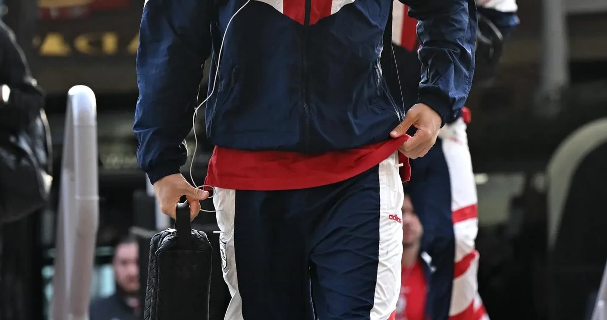 Player arriving in team tracksuit with bag
