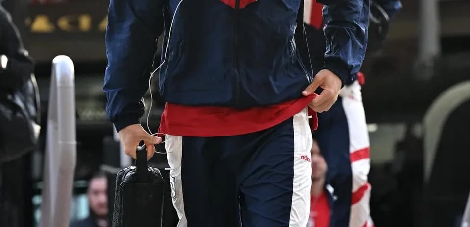 Player arriving in team tracksuit with bag