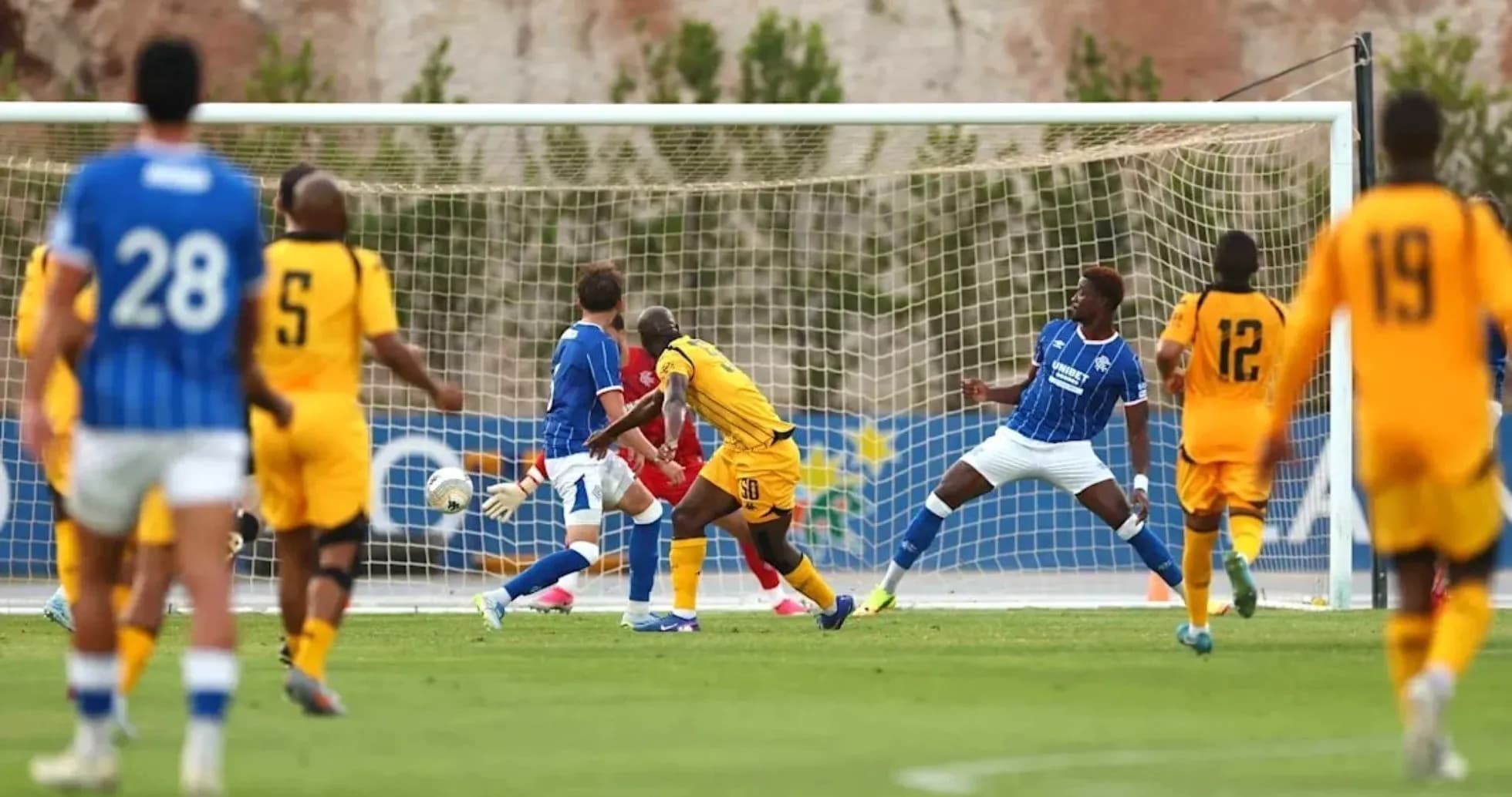 Players competing as a shot approaches the goal