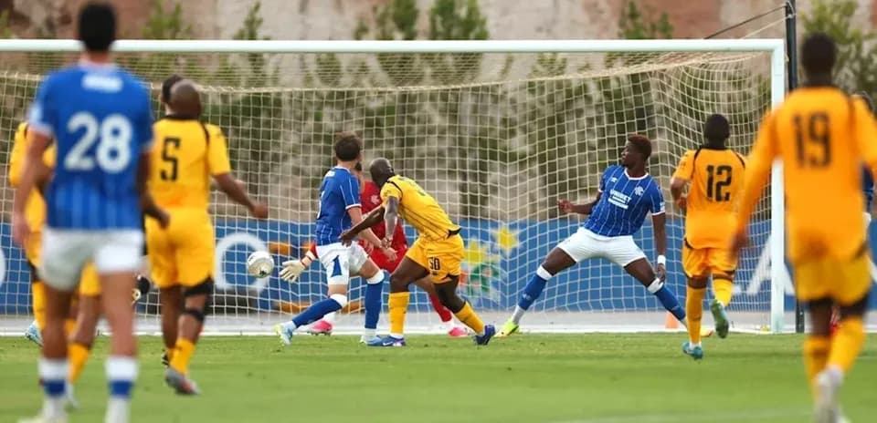 Players competing as a shot approaches the goal