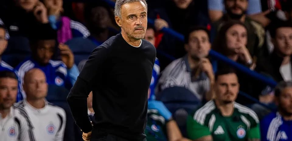 Coach observing game from the sidelines with fans