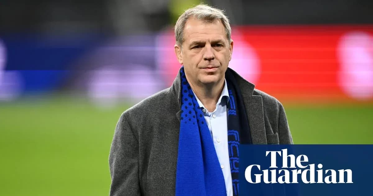 Man in a coat wearing a blue scarf on field