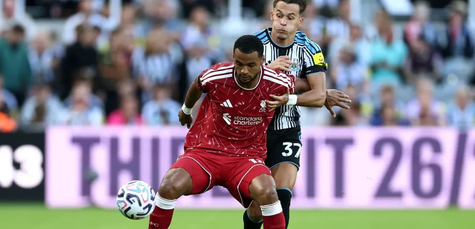 Player from Liverpool evading tackle by Newcastle defender
