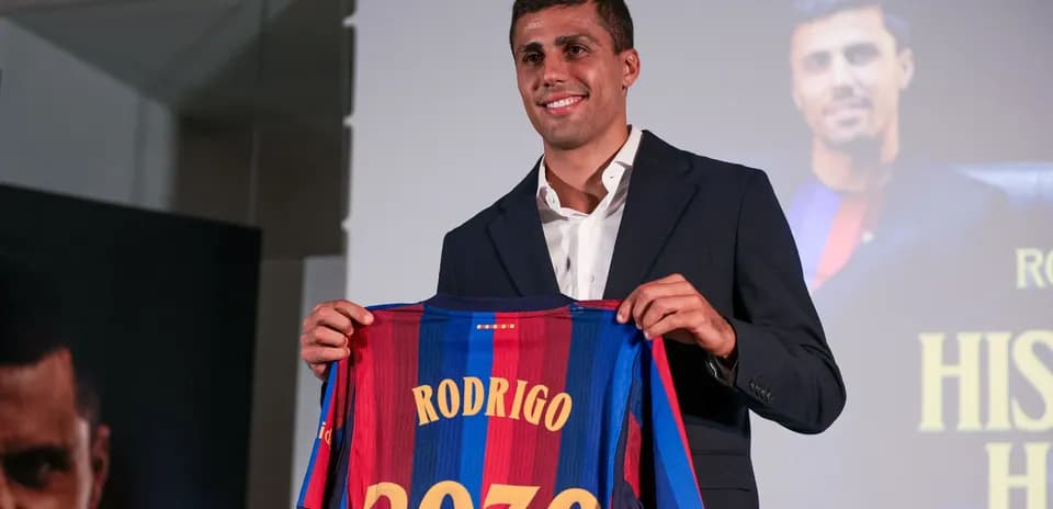 Player holding Barcelona jersey at press conference